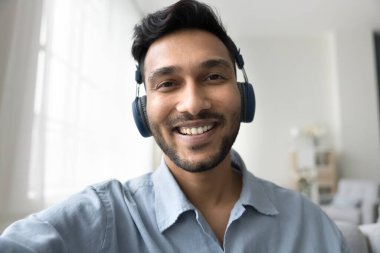 Yüzünüzü kapatın mutlu Hintli adam gülümseyin akıllı telefon kameralarına bakın video görüşmeleri yapın, evde modern uygulamaları kullanarak uzaktan konuşmanın tadını çıkarın. Çevrimiçi yayın, e-randevu hizmetleri, iletişim