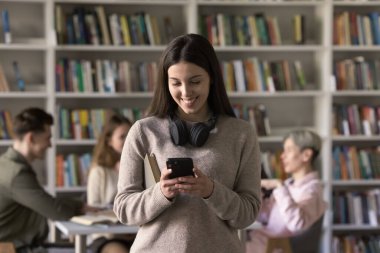 Kütüphanede ya da sınıfta duran ergen kız öğrenci akıllı telefon kullanıyor, arama bilgileri kullanıyor, ara veriyor, arkadaşından mesajlar okuyor, internette sohbet ediyor, zaman çizelgesini mobil uygulamalardan kontrol ediyor. Modern teknoloji, çalışmalar