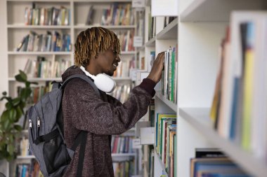 Afrikalı hippi, ilgili öğrenci kütüphanede ders kitabını seçiyor, üniversite başvurusu, üniversite ödevi, sınavlara hazırlanma edebiyatını araştırıyor. Yeni bilgiler ve eğitim al.