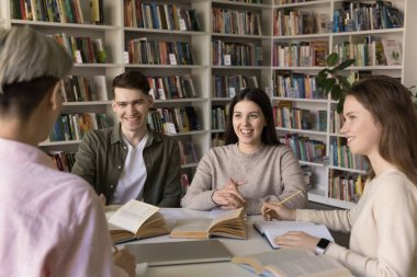 Dört genç, güzel öğrenci, kızlar ve erkekler masada oturup sohbet eder, fikirleri paylaşır, dinle takım lideri kütüphanede toplandı ortak bir görev yapmak için, ödev hazırlar, hikaye öğrenmekten kaçınır.