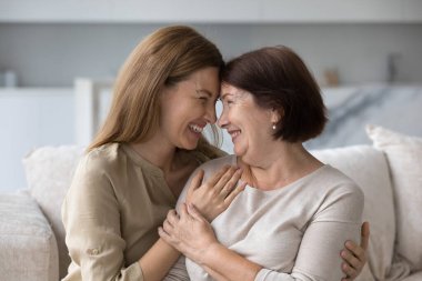 Yetişkin bir kız ve orta yaşlı sevgi dolu bir annenin tatlı şefkatli anları. Kadınlar kanepede oturup birlikte vakit geçiriyorlar. Çok nesilli aile iyi, sıcak ilişkiler, uyum ve anlayış