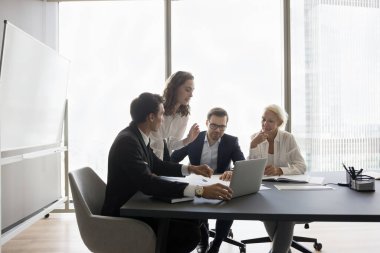 Ekip dizüstü bilgisayarla masada oturur, pazar eğilimlerini analiz eder, mali tabloları gözden geçirir, bütçe planlar, gelir artışı üzerine çalışan pazarlama stratejisini paylaşır, yeni ürün veya hizmetler için fikirleri tartışır