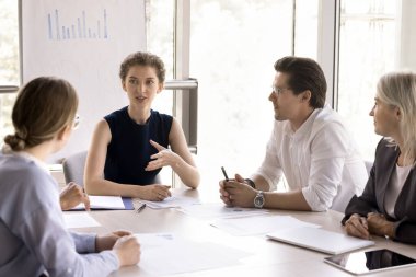 Genç ve hırslı iş adamları, bin yıllık güzel iş kadınlarının brifinglerine katılıyor, konuşmalarını dinliyor, fikir paylaşıyor, görüşlerini paylaşıyor, müşterilerle görüşüyor, şirket hizmetlerini ofiste satıyor.