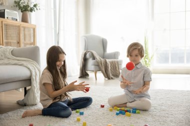 Küçük mutlu çocuklar hafta sonlarını oturma odasında geçirirler, oyuncaklarla oynarlar sıcak zeminde otururlar, evde eğlenirler, kardeşler arkadaşça bir ilişkinin ve oyun zamanının keyfini çıkarırlar. Etkinlik, oyunlar, çocukluk