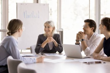 Olgun, güzel iş kadını grup liderleri toplantı masasına oturur, sabah brifingine katılır, modern konferans odasında işbirliği projesini tartışır. İş iletişimi, müzakere