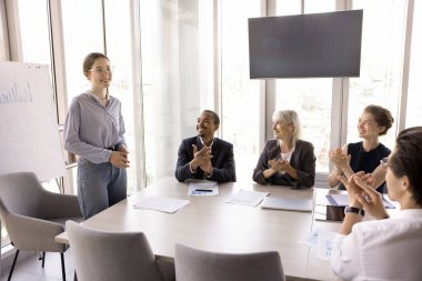 Gülümseyen dost canlısı çalışanlardan oluşan bir grup, personel üyeleri yeni çalışanı alkışlıyor, konuşmadan önce tezahürat yapıyor, genç meslektaşlarını cesaretlendiriyor, eğitmenlerine saygı ve takdirlerini sunuyorlar.