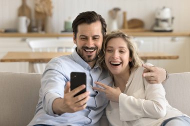 Mutlu 30 'lu yılların çifti cep telefonu kullanıyor. Fotoğraf çektirip fotoğraf çektiriyorlar. Selfie çektiriyorlar, neşeli görünüyorlar.