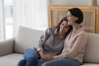 Mutlu kıdemli anne, sevgi, ilgi, destek, gülümseme, gülücük, yetişkin çocukla konuşma, aile toplantısından zevk alma, yakın ilişkiler, yakınlık, annelik gibi olumlu kız çocuğuna sarılıyor.