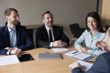 Bir grup gülümseyen pozitif çalışan, iş adamı sabah brifinglerinde güncel işleri halleden, gayri resmi toplantılar yapan, şakaların keyfini çıkaran, mutlu, arkadaşça ilişkiler kuran ve başarılı takım çalışması yapan insanlar.