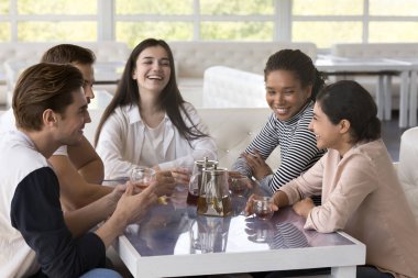 Genç, mutlu, çok ırklı arkadaşlar, toplantı sırasında rahat kafeteryadaki masada oturup çay içerek, eğlenceli hikayeler anlatarak, şakalaşarak, sohbetin tadını çıkararak, kafede toplanırlar. Arkadaşlık.