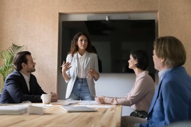 Kendine güvenen bayan, iş kadını toplantı odasında iş ortaklarına veya yatırımcılara sunum yapıyor, çalışanları eğitiyor, pazarlama semineri stratejisini anlatıyor, projeyi tartışıyor, satış sonuçlarını anlatıyor