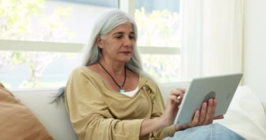 Pozitif odaklı son sınıf öğrencisi, serbest internet başvurusunu tablet üzerinde kullanıyor, sosyal medyayı, interneti tarıyor, mutlu oluyor, gülüyor, rahat koltukta dinleniyor, cihaz tutuyor.
