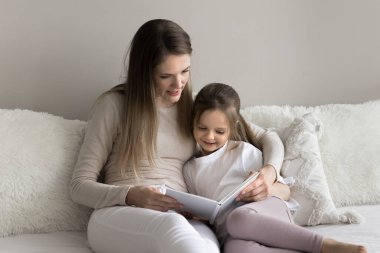 Sevgi dolu genç bir anne küçük kızıyla oturur, evde kağıt kitaplarla vakit geçirir, ilginç peri masalları okur, favori hobilerinin tadını çıkarır. Çocuk gelişimi, eğitim, iyi yaşam alışkanlığı