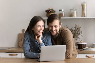 Mutlu milenyum çiftleri mutfakta dizüstü bilgisayarlarıyla, web siteleriyle, alışveriş yaparak, komik haberler okuyarak, sosyal ağlarda sohbet ederek, web sörfü bilgisiyle, hafta sonları internette birlikte vakit geçirerek