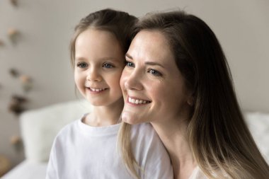 Güzel bir anne ve küçük bir kızın yakın portresi. Sabahları gülümseyerek evden uzağa bakıyor. Aile bağı ve bağlar, mutlu kadın anneliğin tadını çıkar, sevimli anaokulu çocuğuyla vakit geçir.