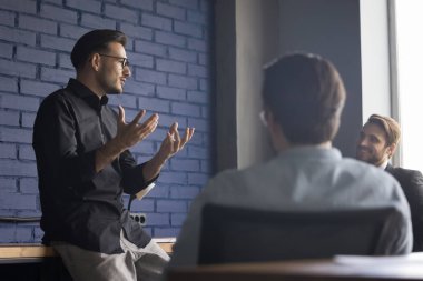Başarılı çekici genç patron, müşterilerine modern yönetim kurulunda sunum yapıyor. Kendine güvenen işadamı şirket toplantısını yönetir, eğitim personelini yönetir, talimatları verir. Brifing, takım oluşturma