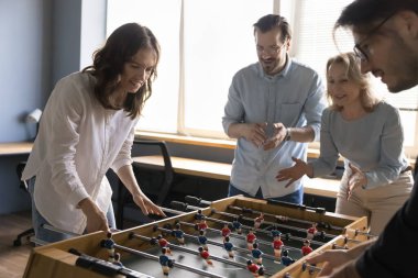 Modern ofiste langırt oynayan dört yaşlı ve genç işçi, kapalı mekanda masa üstü futbolu oynuyorlar, iş yerinde kaygısız bir mola veriyorlar. Hobi, takım oluşturma etkinliği, eğlence