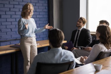 Neşeli şirket lideri kadın genç çalışana seminer veriyor, proje üzerinde tartışıyorlar. Kendine güvenen akıl hocası iş adamlarına yeni proje stratejisini açıklar. Brifing, danışmanlık, takım çalışması