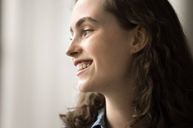 Samimi gülüşü olan hayalperest genç kadın uzaklara bakıyor, hoş düşüncelerin derinliklerinde, umutlarla dolu, mutlu, kapalı bir yerde dinleniyor. Nostaljik ruh hali, anıları hatırlamak, yüz görünümünü kapatmak.