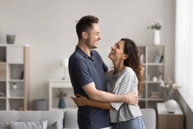 Milenyum Latin çifti modern oturma odasında birbirlerine sarılıyorlar. Genç kiracılar gülüyor, sarılıyor, taşınmaktan zevk alıyor, zevkli sohbetler ve ahenkli ilişkiler. Kiracılar, taşınma gününde yeni apartman sahipleri