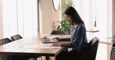 Asyalı çalışan çalışma masasında oturup kağıtlara basılmış çizelgeleri ve grafikleri inceleyecek, veri araştırması yapacak, dizüstü bilgisayarla iş akışına dahil olacak. Satış performansı, piyasa eğilimleri, finansal ölçüm analizleri