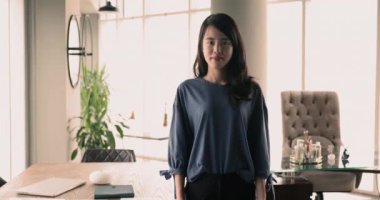 Gülümseyen Asyalı kadın bireysel girişimci serbest iş kadını portresi ev ofisinde kollarını kavuşturmuş kameraya bakıyor, mesleki gelişimin ve iş büyümesinin keyfini çıkarıyor.