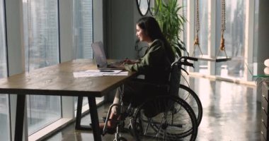 Modern ofis işkadını Latin iş kadını, girişimci işleri uzaktan çözer, çevrimiçi iş yapar, şirket müşterilerine e-posta ile cevap verir, tekerlekli sandalyede oturan meslektaşlarına karşılık verir. Çalışma akışı, teknoloji