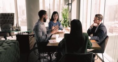 Engelli erkek takım lideri müvekkilleriyle tekerlekli sandalyede oturuyor. Afrikalı işletme eğitmeni başkanlığındaki brifing, personelle seminerde bilgi, bilgi ve deneyim paylaşım fikirleri sunmaktadır.