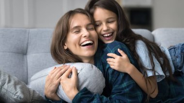 Mutlu, aktif, sevgi dolu bir anne, tatlı bir kızı sırtında taşıyor. Kanepede dinleniyor, gülüyor, çocukla vakit geçiriyor, anneliğin tadını çıkarıyor. Heyecanlı anne ve tatlı çocuk eğleniyor. Sancak vuruşu