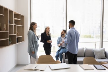 İş arkadaşlarınız iş yerinde mutlu bir şekilde toplanıyor, molada koltuk ve işyerinde duruyor, çay içiyor, kahve içiyor, konuşuyor, sohbet ediyor, gülüyor, eğleniyor, arkadaşça iletişim kuruyor.