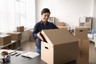Küçük işletme sahibi, kadın depo işçisi sevkiyat için paket hazırlıyor, kutuyu güvenilir kurye şirketi aracılığıyla gönderiyor. Satış platformu ve elektronik ticareti kullanan çevrimiçi mağaza tüccarlarının iş akışı