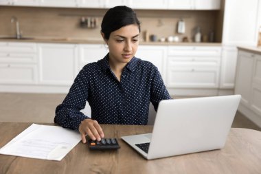 Ciddi Hintli kadınlar finansman yönetir, internet bankacılığı ve finansal yönetim platformları aracılığıyla faturaları öder, hesap bilgilerine erişir, mali araçlar kullanır, kişisel bütçeyi korur