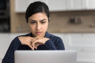 Çevrimiçi kullanım dizüstü bilgisayarında çalışan ciddi Hintli kadınları kapatın, önemli bildirimleri okuyun, internetten bilgi arayın, sözleşme dönemini gözden geçirin, karar verin, düşünün, merkez ofiste araştırma yapın
