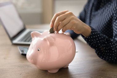 Kesilmiş manzarayı kapat bilinmeyen kadın eli pembe kumbaraya para koy, gelecek ihtiyaçlar ve büyük alışverişler için para biriktir. Ailenin mali işleriyle ilgilenen pratik bir kadın. Mali planlama