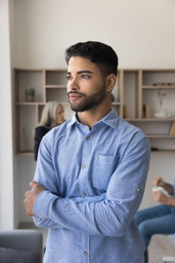 Düşünceli, yakışıklı, genç bir Arap şirket yöneticisi. Elleri bağlı bir şekilde ofis çalışma yerinde duruyor, samimi bir portre için poz veriyor, başka tarafa bakıyor, iş kariyerini düşünüyor. Dikey çekim