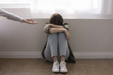 Yerde oturmuş ağlayan bir kız, destek, yardım, teselli ve kavga üstüne özür işareti gibi anne eli ona uzanıyor. Yanlış anlama, kuşak farkı, gençlik sorunu.