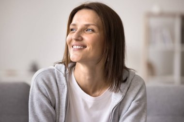 Güzel, orta yaşlı bir kadın, gündelik giysiler içinde oturma odasında koltukta dinleniyor ve uzaktaki bir yere bakıyor. Yeni dairede parlak bir gelecek hayal ediyor. İyimser bir ruh hali ve hoş anıları var.