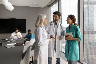 Üç doktor, Hintli, Avrupalı ve İspanyol dahiliyeciler modern klinik ofisinde duruyor, görüşlerini, becerilerini, sezgilerini paylaşıyorlar. Tecrübeli ve genç sağlık uzmanları arasındaki konuşma