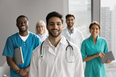 35 'lik hırslı genç Arap erkek doktorların kafalarından vuruşları modern ofisteki çeşitli iş arkadaşlarıyla birlikte beyaz önlük giyiyor. Sağlık uzmanları, klinik çalışanları portreler, tıp