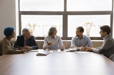 Beş genç ve olgun çok ırklı personel konferans masasında brifing veriyor. Hissedarlar şirketin mali bildirisini gözden geçirirler, karları, kayıpları, gelirleri, kar payı ve politikaları tartışırlar