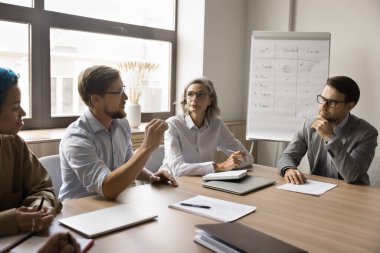 Erkek konuşmacı, ofisteki müzakere sırasında hissedarlara bilgi sağlar, resmi toplantıda yer alır, görüşlerini ve stratejilerini paylaşır, yönetim kurulunda toplanan işbirliğini planlar.
