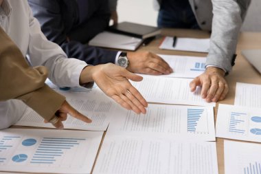 Close up group businesspeople, partners planning strategy based on data, analyzing charts and graphs shown on printed paper material, review statistics results engaged collaborative approach, teamwork clipart