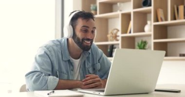 Büyük kulaklıklı mutlu İspanyol iş adamı video konuşmasında konuşuyor, bilgisayarını serbest iş iletişimi için kullanıyor, ekranda el sallıyor, gülümsüyor, çevrimiçi konferansta konuşuyor.
