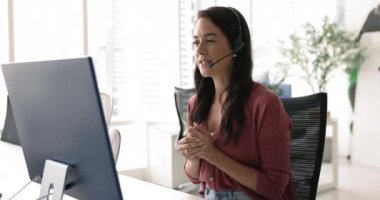 Genç kadın, yardım hattı çalışanı, müşteri sorunlarını video çağrı uygulaması veya internet üzerinden çözer, teknik sorunları çözmede yardımcı olur, müşteri soruşturmalarını etkili bir şekilde ele alır