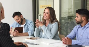 Pozitif HR takım yöneticisi kadın kıdemli iş adayıyla görüşüyor toplantıda konuşuyor, gülümsüyor. Çeşitli iş ortakları müzakere masasında konuşuyor, proje, anlaşma, işbirliği tartışıyorlar.