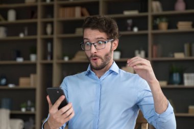Afallamış bir adam akıllı telefon ekranına bakıyor, gözlerini kapatıyor, büyük, inanılmaz haberlerle gelen mesajı okuyor, fantastik satışlar yapıyor, büyük indirimli ticari teklifler alıyor, çevrimiçi piyango kazanıyor.