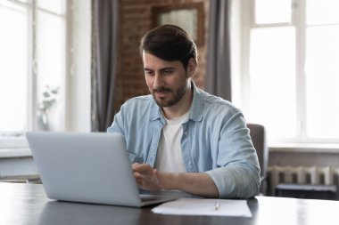 Klavyede dizüstü bilgisayarda yazan adam modern ofis çalışma alanında masa başında oturuyor. Freelancer çevrimiçi telekomünikasyon işi yapıyor, müşteriye e-posta ile mesaj atıyor, uzaktan iş çözüyor. Teknoloji kavramı