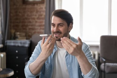 Genç işadamı hoparlörden konuşur, sesli mesaj bırakır, akıllı telefon kullanır iş yerinde oturur. Sanal yardımcı uygulamalar, hatırlat, dijital yapay zeka mobil yardımı, modern teknoloji kullanımı konsepti