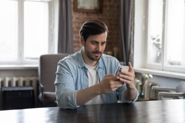 Milenyum çalışanı çalışma masasında ya da iç işlerinde oturur mesajlar alır, internette sohbet eder, akıllı telefonda mobil profesyonel iş uygulaması kullanır, dijital teknoloji uygulaması, iş hayatı konsepti