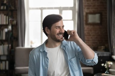 Ofiste duran başarılı iş adamı iş görüşmelerini gülümsetir, kenara bakar, iyi haberler alır, müşterilere hoş sohbetler sunar iş akışının keyfini çıkar, modern kablosuz teknoloji kavramını kullan.